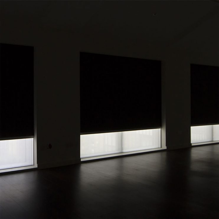 Media room with fully recessed blackout shades lowered over the windows