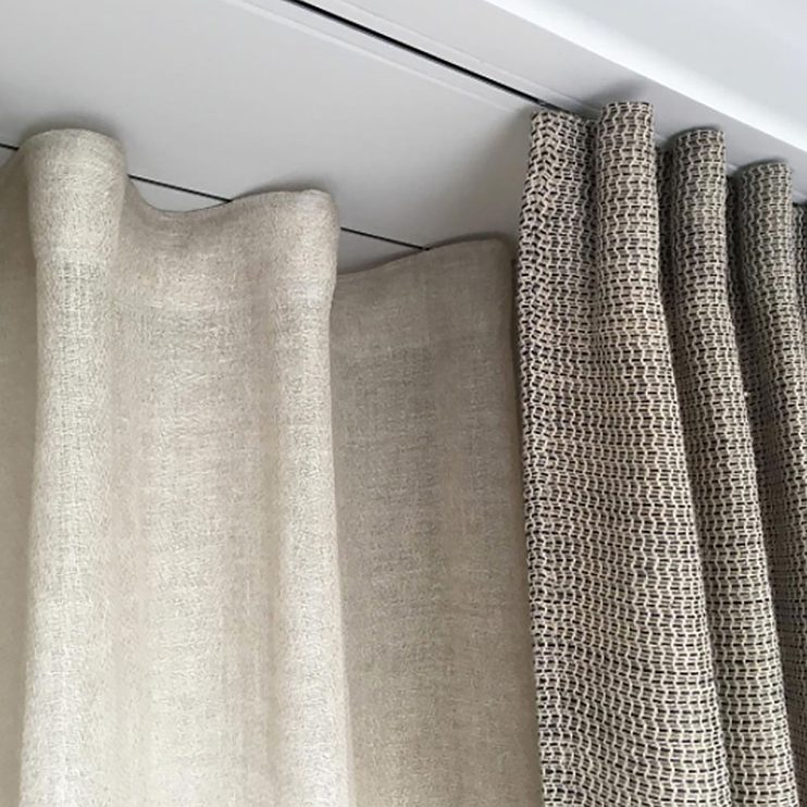 Linen drapery hanging from a recessed ceiling curtain track with no visible hardware