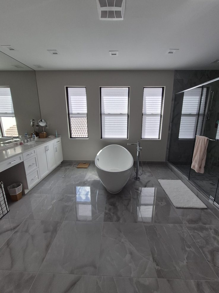 Privacy shades above a freestanding tub in a modern South Florida bathroom