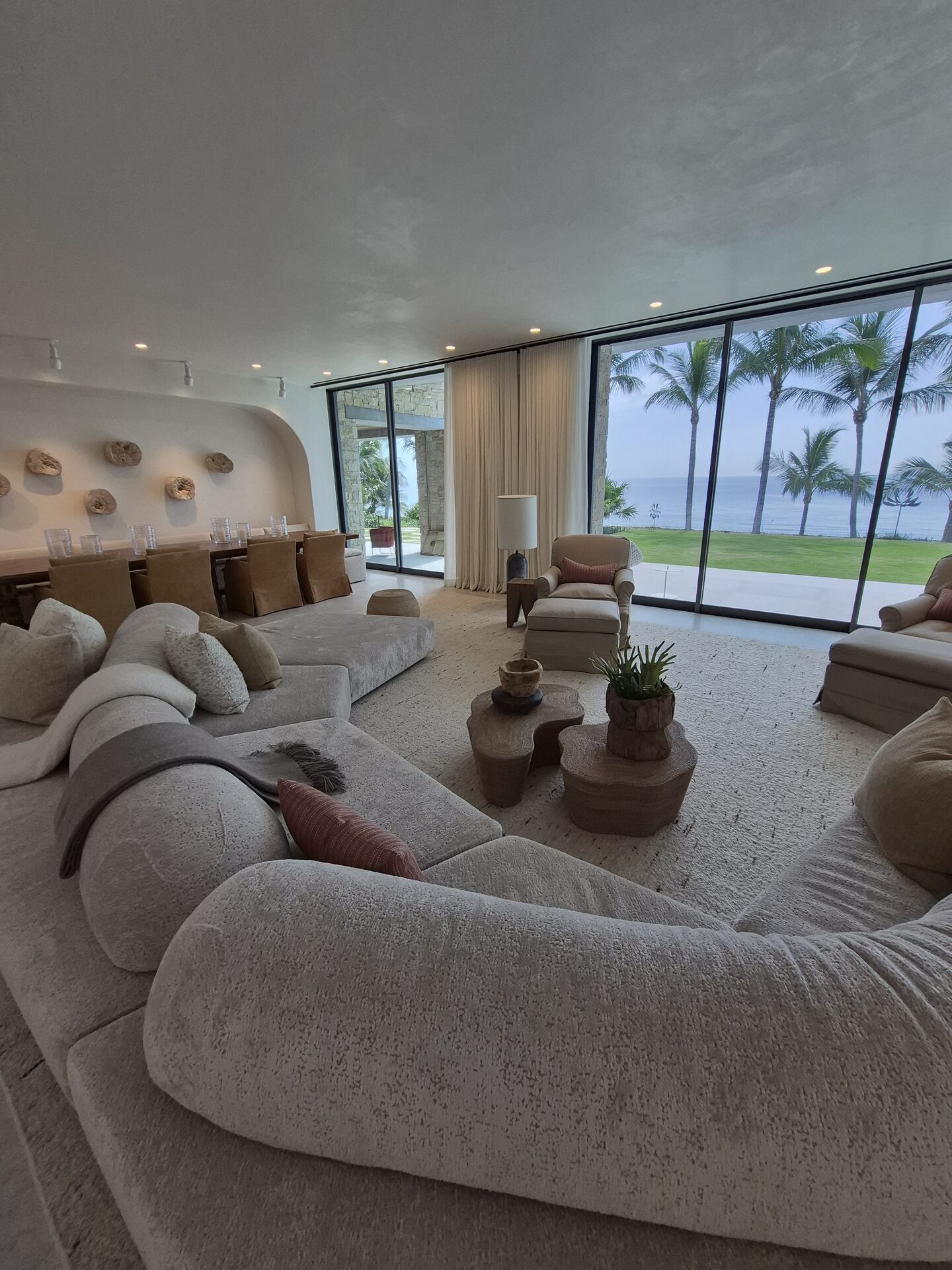 Sheer draperies in a beachfront living room with ocean and palm views