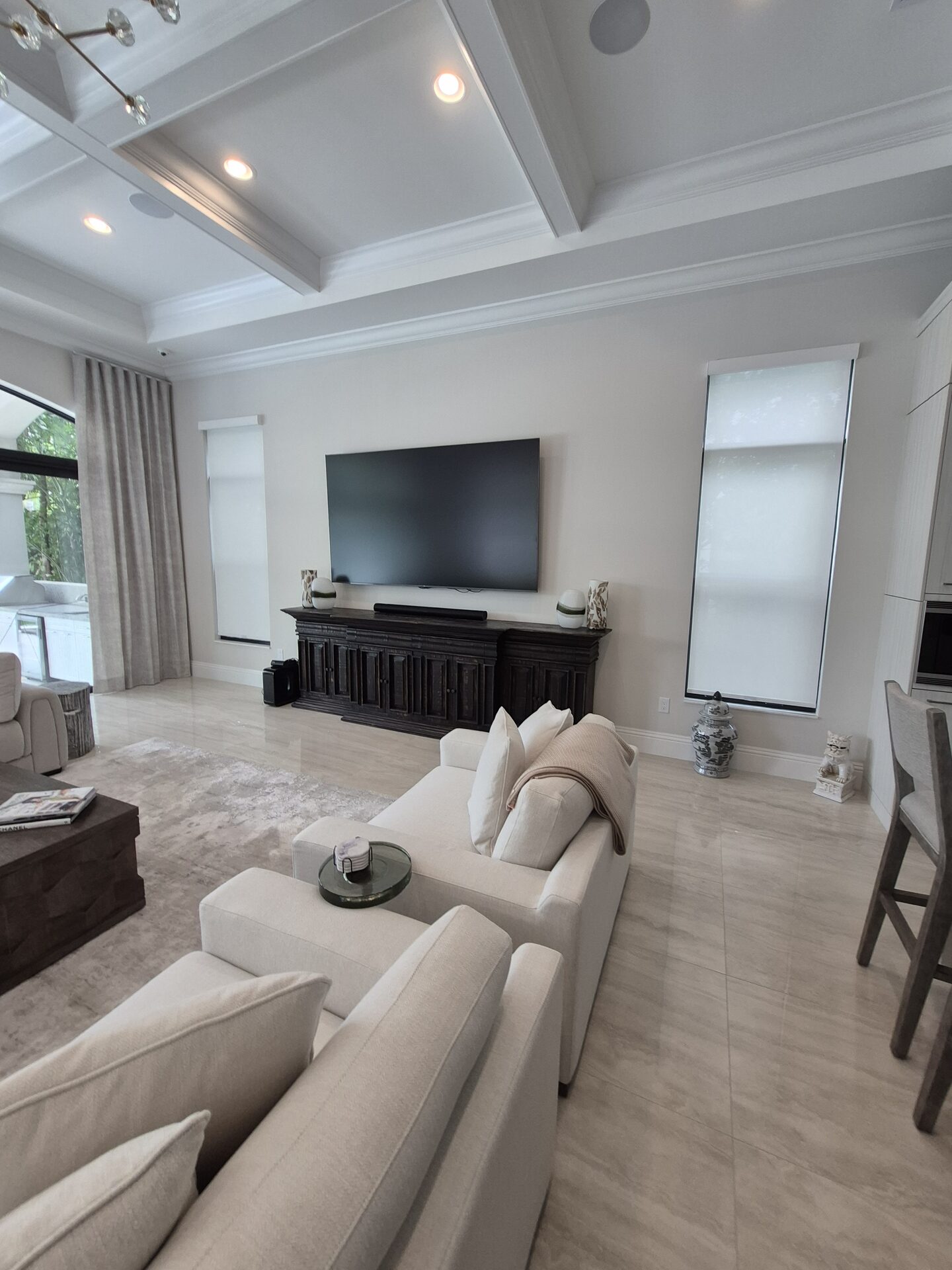 Motorized roller shades in a coffered-ceiling estate living room