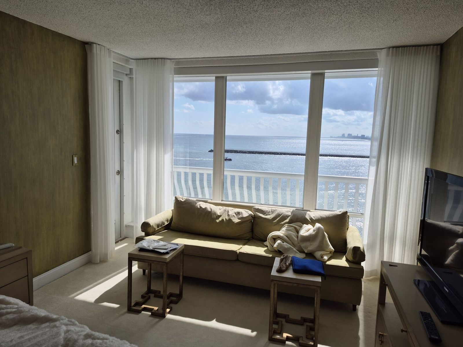 Floor-to-ceiling sheer draperies on a motorized track across an oceanfront sliding glass wall
