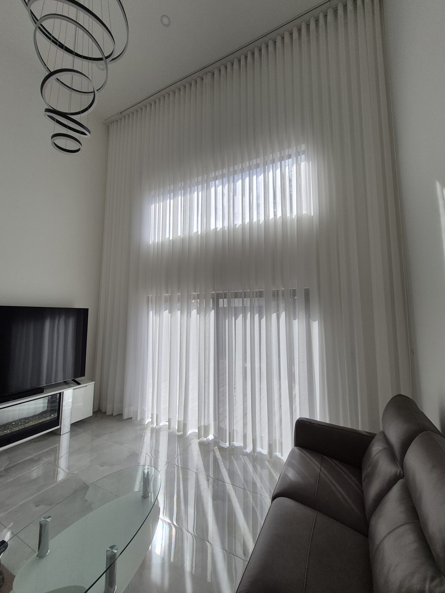 Tall sheer drapery diffusing daylight in a South Florida residence