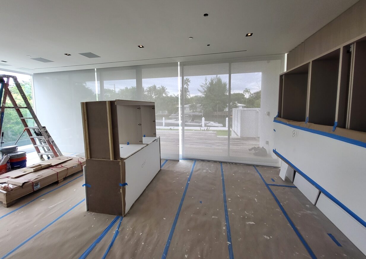 Floor-to-ceiling sheer draperies in a waterfront living room
