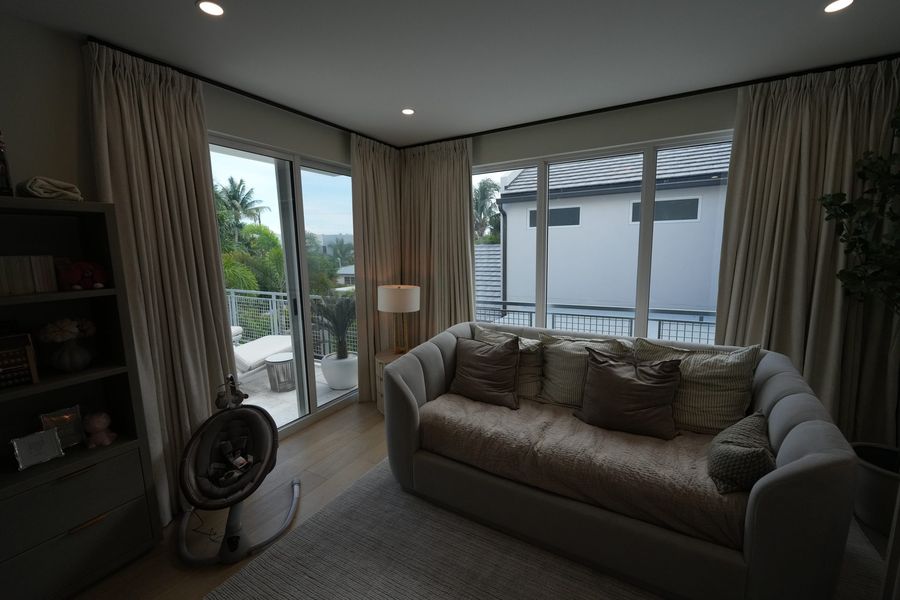 Ripplefold draperies stacked open beside sliding doors to a pool, Fort Lauderdale