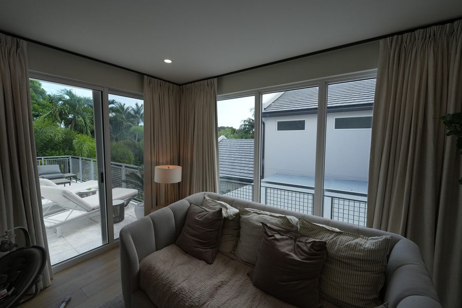 Ripplefold draperies framing the view of a pool, Fort Lauderdale