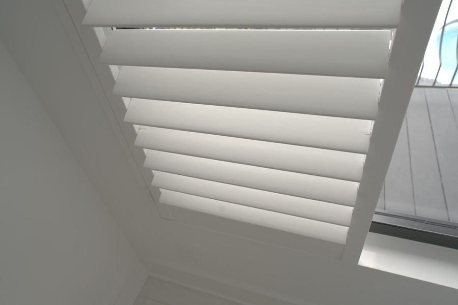 Close-up of lacquered basswood plantation shutter louvers with no visible tilt rod, guest house, Boca Raton