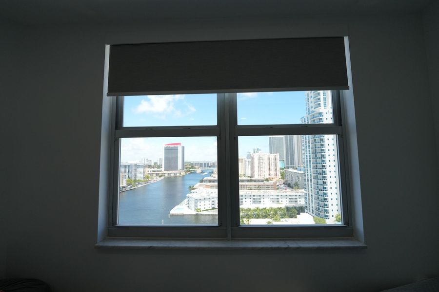 Elba Twilight blackout roller shade partly lowered in a Hallandale Beach bedroom