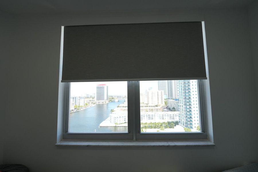 Blackout roller shade at mid height over a marina view, Hallandale Beach