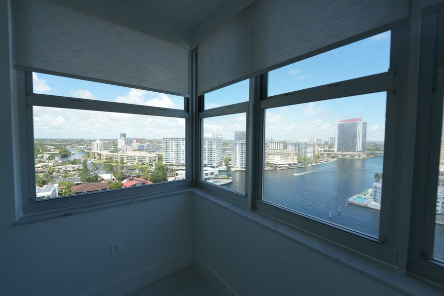 Living room windows with roller shades raised over the Intracoastal, Hallandale Beach high-rise