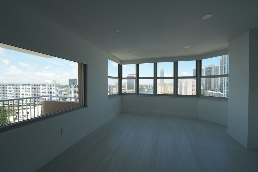 Light-filtering roller shades lowered across living room windows, Hallandale Beach