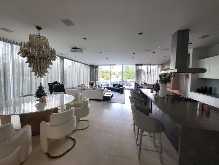 Dining and kitchen area with sheer draperies and a sculptural chandelier, Miami Beach