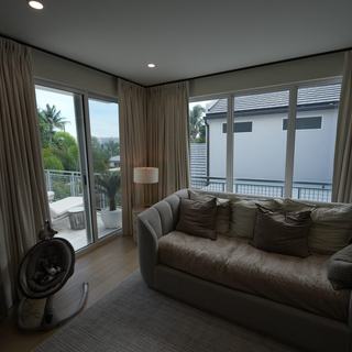 Ripplefold draperies stacked open beside sliding doors to a pool, Fort Lauderdale
