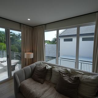 Ripplefold draperies framing the view of a pool, Fort Lauderdale