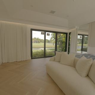 Ripplefold drapery drawn open in a Boca Raton master bedroom with the golf course visible through the glass doors