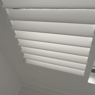Close-up of lacquered basswood plantation shutter louvers with no visible tilt rod, guest house, Boca Raton