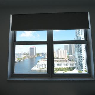 Elba Twilight blackout roller shade partly lowered in a Hallandale Beach bedroom