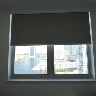 Blackout roller shade at mid height over a marina view, Hallandale Beach
