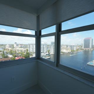 Living room windows with roller shades raised over the Intracoastal, Hallandale Beach high-rise