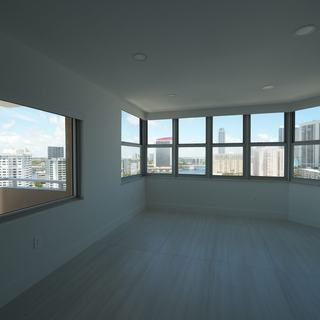 Light-filtering roller shades lowered across living room windows, Hallandale Beach