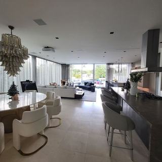 Dining and kitchen area with sheer draperies and a sculptural chandelier, Miami Beach