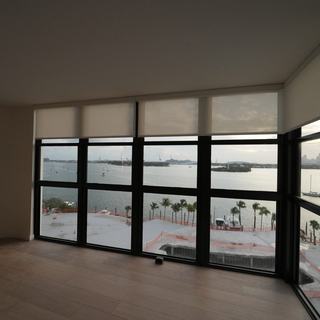 Roller shades half lowered on a glass wall facing the bay, South Beach, Miami Beach