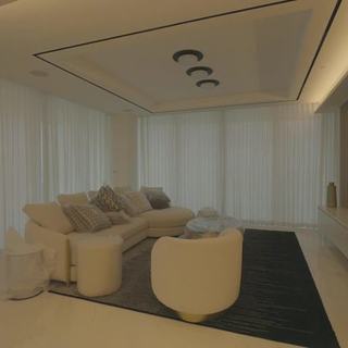 Living room with wood built-in, cove lighting and motorized sheer draperies in Sunny Isles Beach