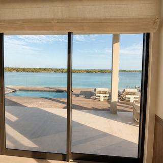 Lutron blackout shade on a floor-to-ceiling slider with pool view, Turks and Caicos