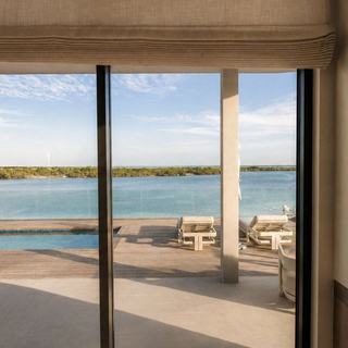 Villa living room with Lutron blackout shades overlooking the pool and ocean, Big Ambergris Cay, Turks and Caicos