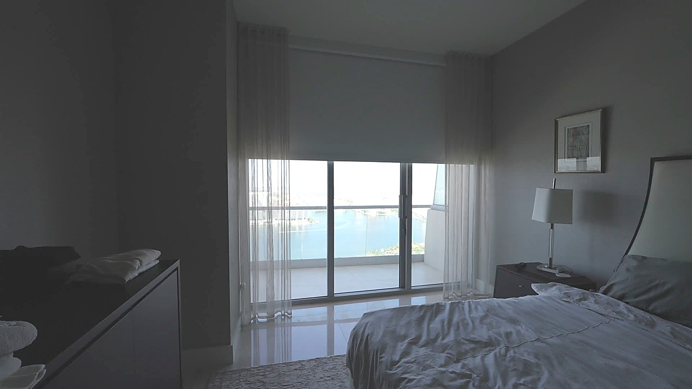 Bedroom blackout roller shade travelling down over the Intracoastal view with sheers at each side, Turnberry Ocean Club