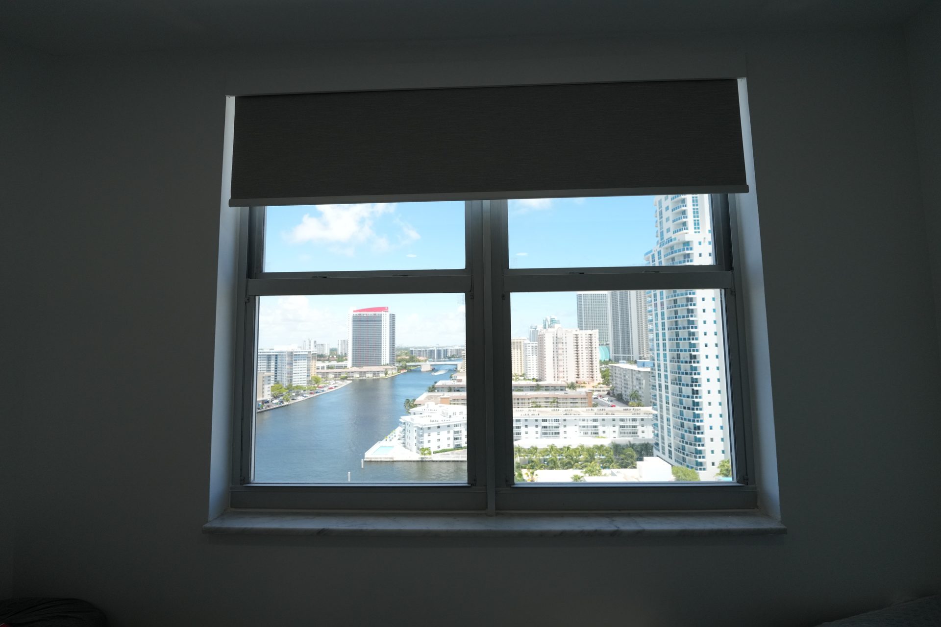 Elba Twilight blackout roller shade partly lowered in a Hallandale Beach bedroom