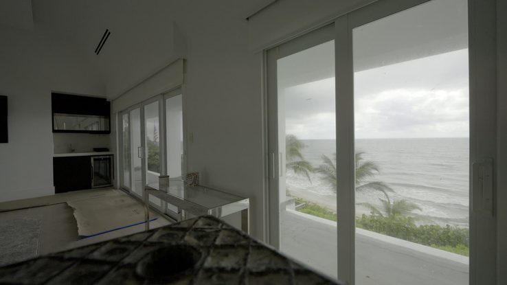 Motorized solar shades on the kitchen and dining ocean wall