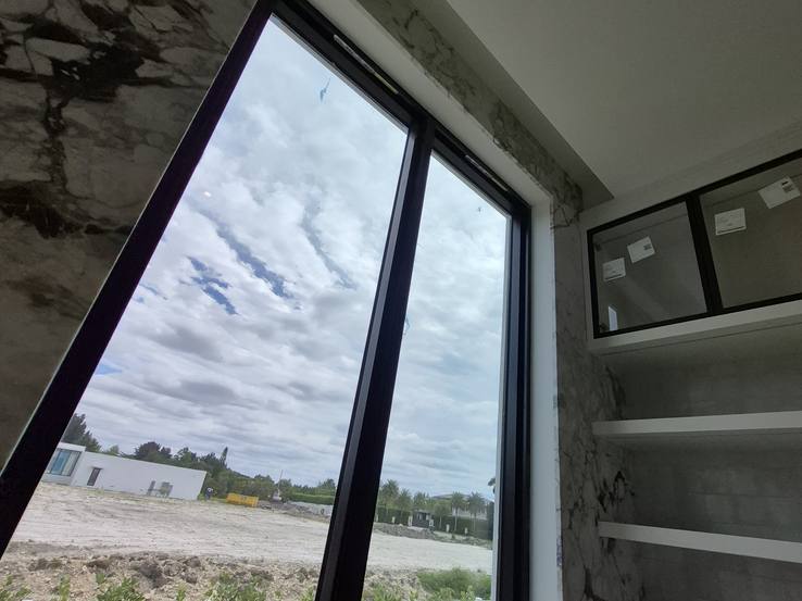A tall window beside the marble wall before any shades, on measuring day