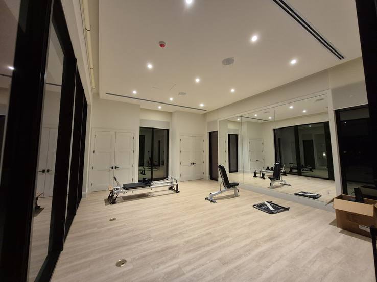 The gym at night with the coupled roller shades raised into their ceiling pockets