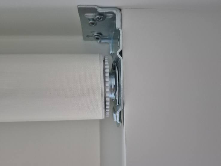 The end of a roller shade in its bracket inside the ceiling pocket