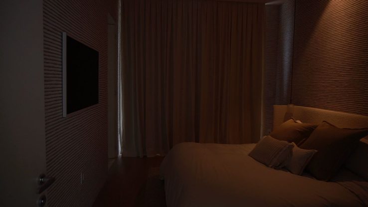 Bedroom with blackout draperies fully closed showing complete light control