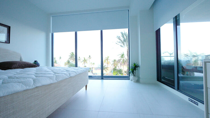 Bedroom in the second unit with the blackout shades raised over the palms