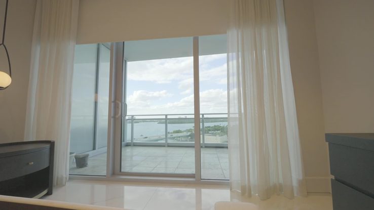 Bedroom sheers at the open slider with the bay beyond
