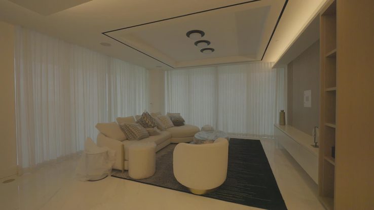 Living room with wood built-in, cove lighting and sheer draperies