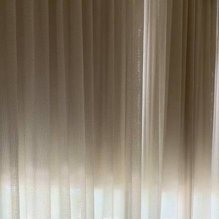 Coulisse Como blackout roller in Shell halfway down behind the primary bedroom drapery