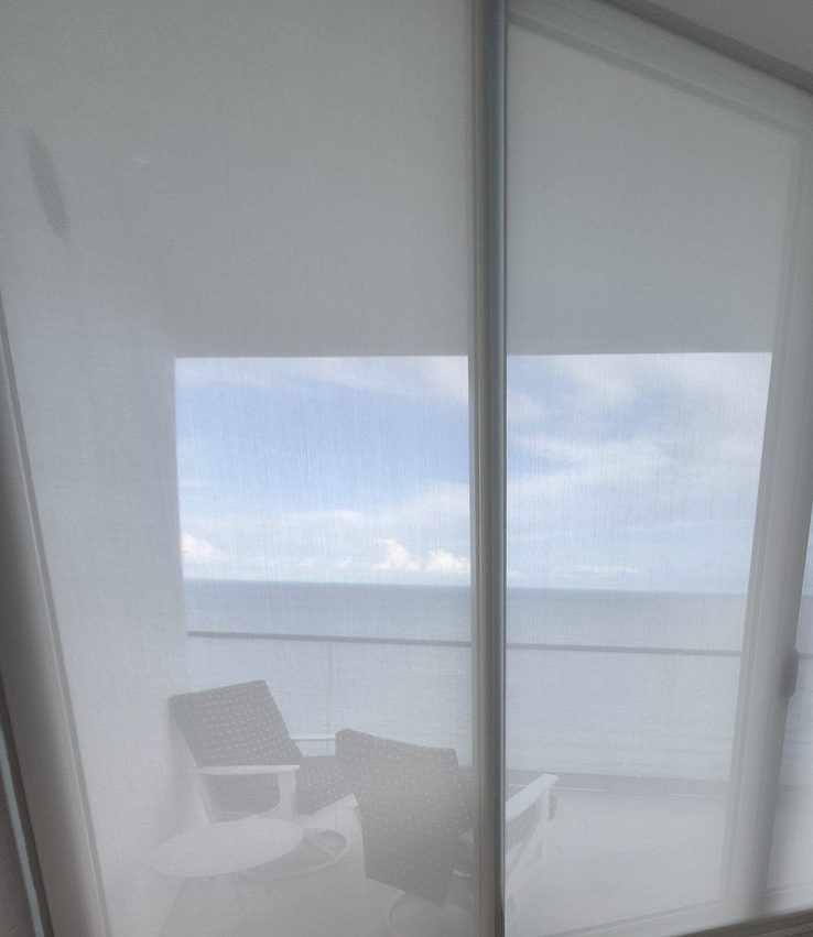 Solar screens on the terrace slider with patio furniture reading through the fabric
