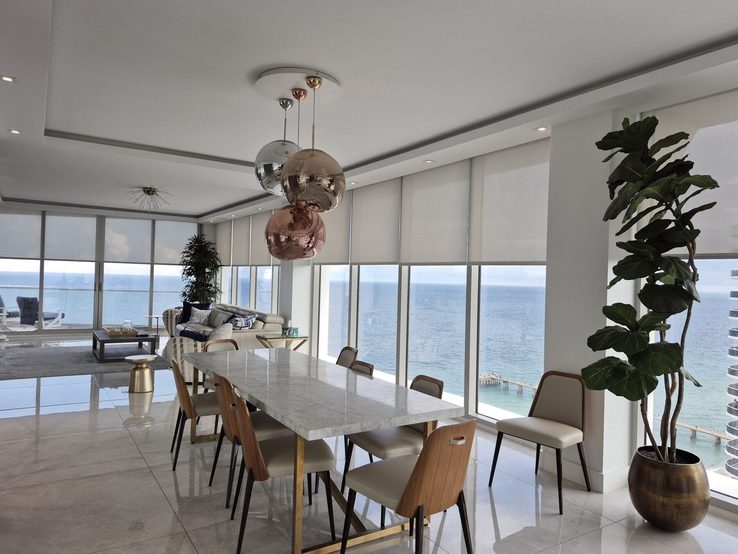 Dining room at Trump Tower III looking down the length of the residence with every shade pocketed into the ceiling