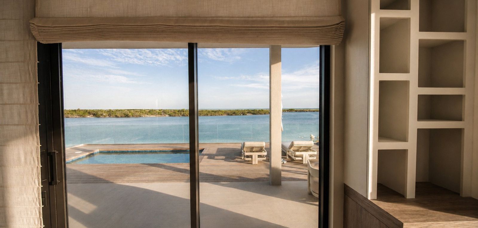Villa terrace with motorized exterior screens overlooking a pool, Turks and Caicos